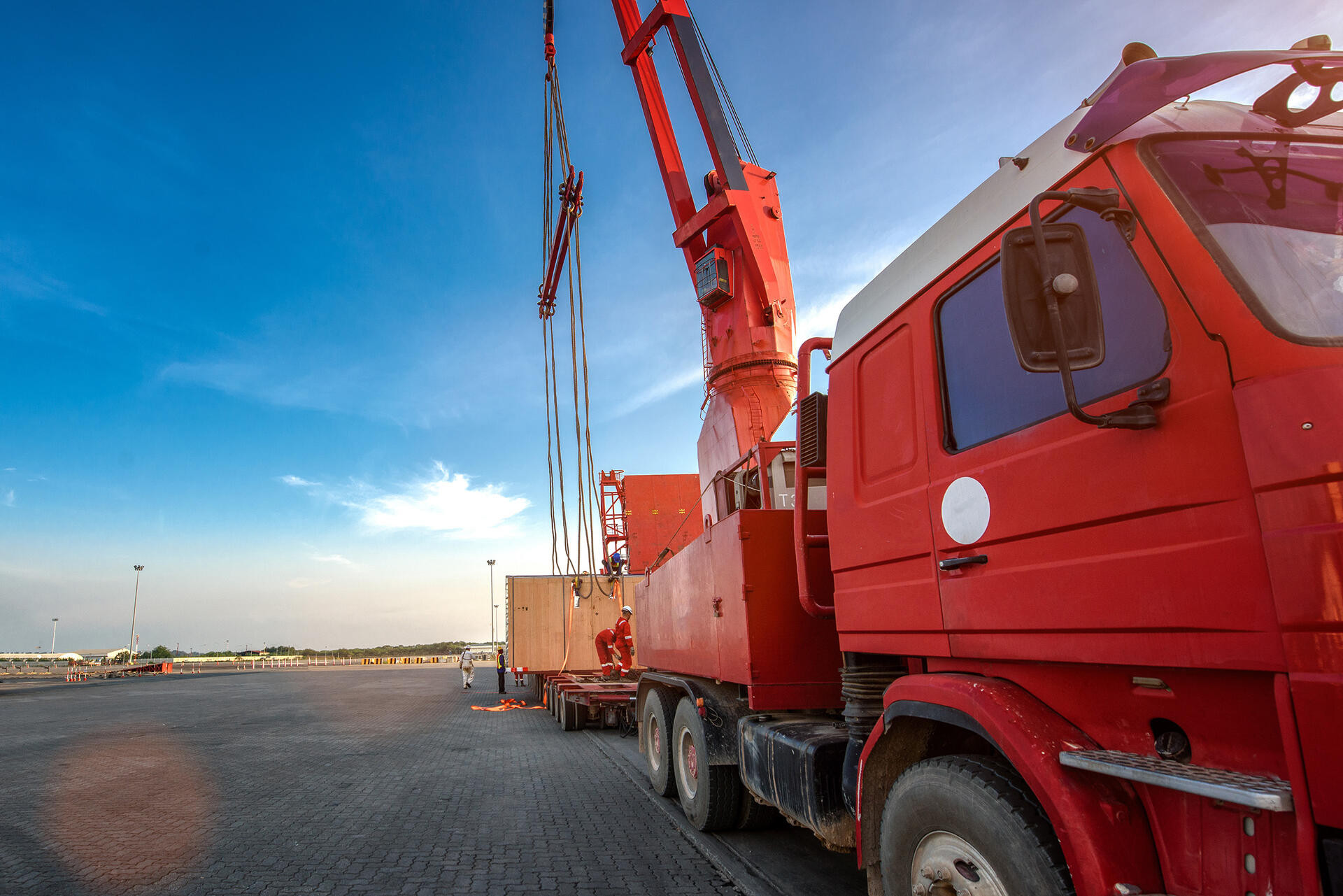transportation of the logistics services on the heavy lift cargo transfer loading from the ship carry onto the lowbase trailer by professional working teams in port terminal